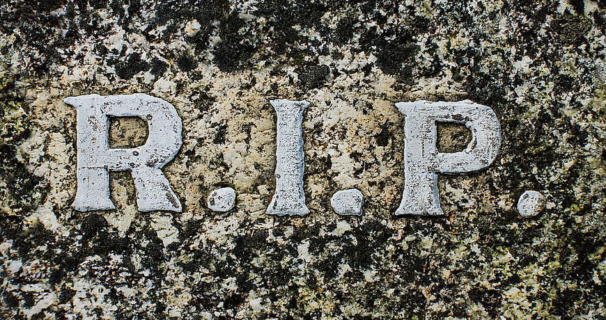 Close-up of R.I.P. inscription on weathered granite gravestone