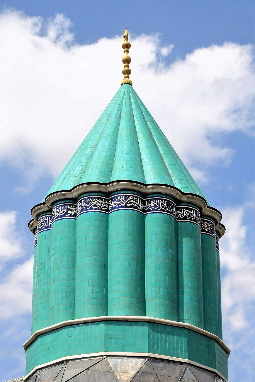 Green Tiled Minaret Dome With Arabic Calligraphy Against Blue Sky