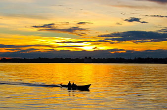 Silhouetted Boat on Golden Sunset Lake