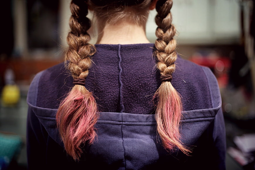 Back view of girl with pink-tipped braids in purple hoodie