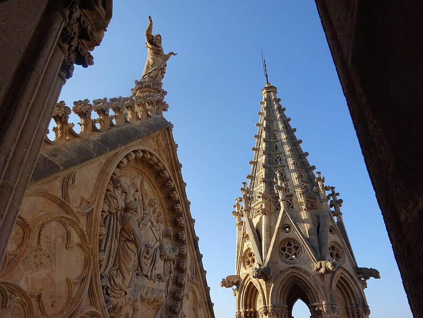 Gothic Cathedral Spire and Sculpture Detail Against Blue Sky