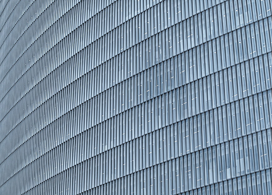 Modern Glass Building Facade with Diagonal Metal Louvers