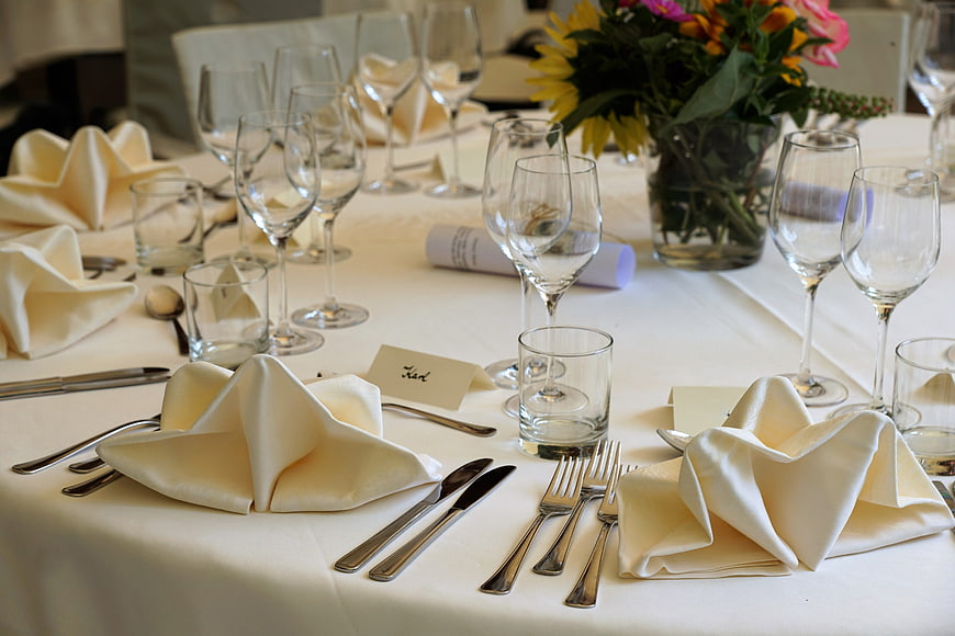 Elegant Formal Table Setting With White Linens And Floral Centerpiece