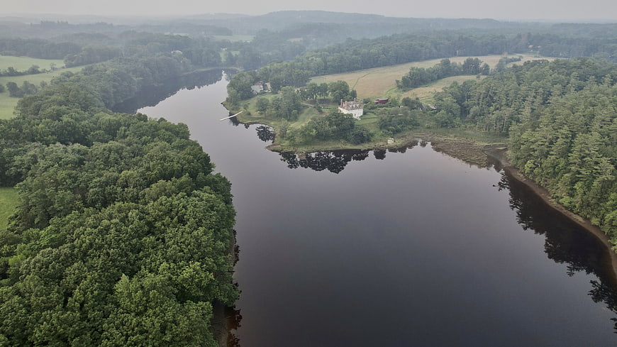 Aerial View of Serene River Bend with Forest and House