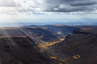 Dramatic Mountain Valley with Sunbeams and Autumn Foliage