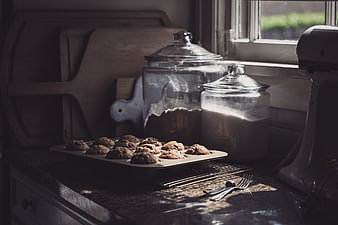 Freshly baked muffins on kitchen counter with flour jars