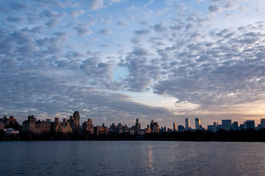 Manhattan Skyline at Dusk Over Lake with Cloudy Sky