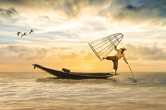 Fisherman Casting Net on Boat at Sunset