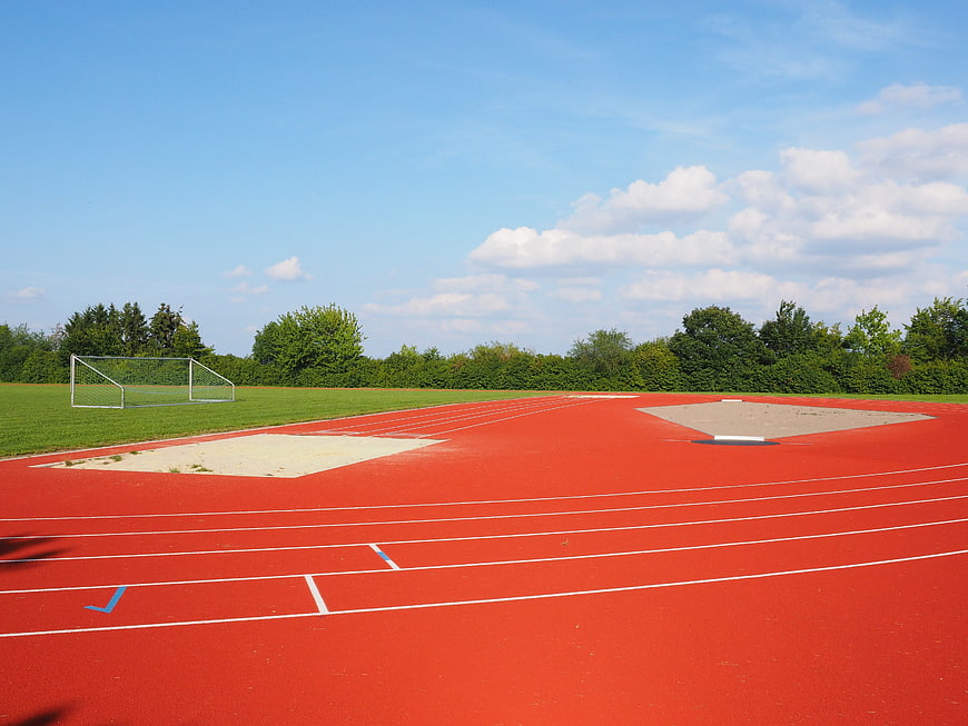 Red athletics track with sand pits and blue sky