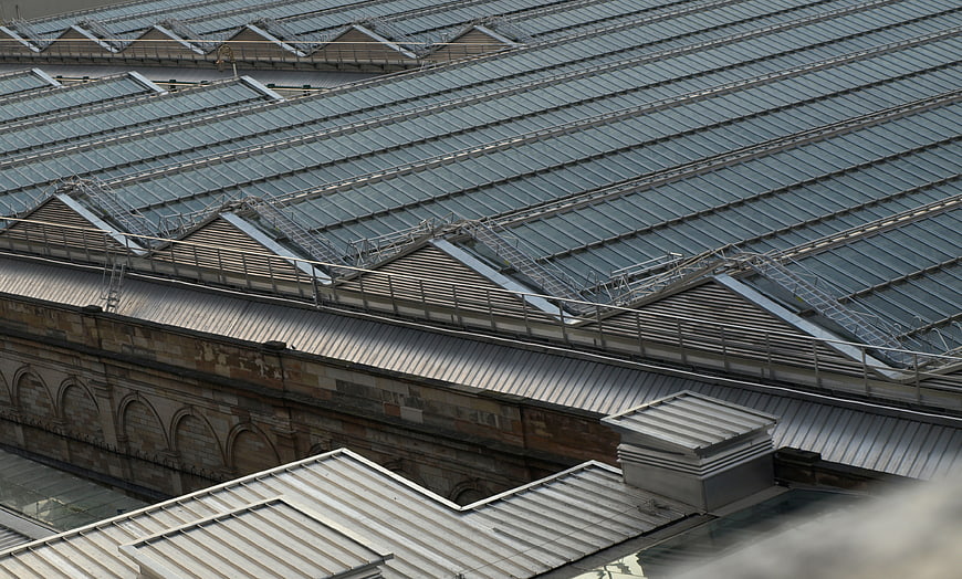 Aerial view of industrial glass roof with metal framework and brick walls
