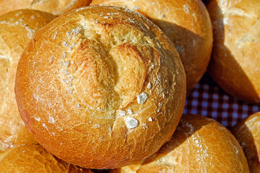 Close-up of fresh golden bread rolls with flour dust