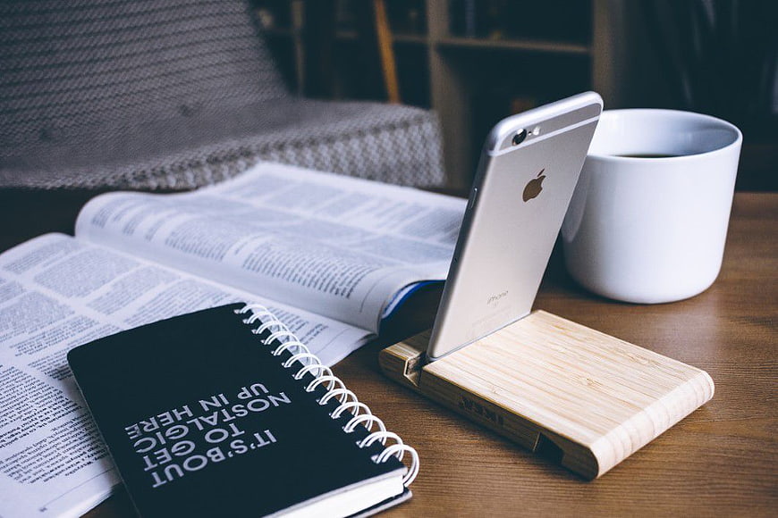 iPhone on Wooden Stand with Book and Coffee