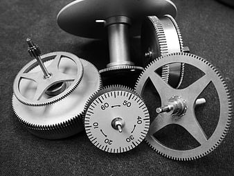 Grayscale mechanical gears and dial on dark textured background