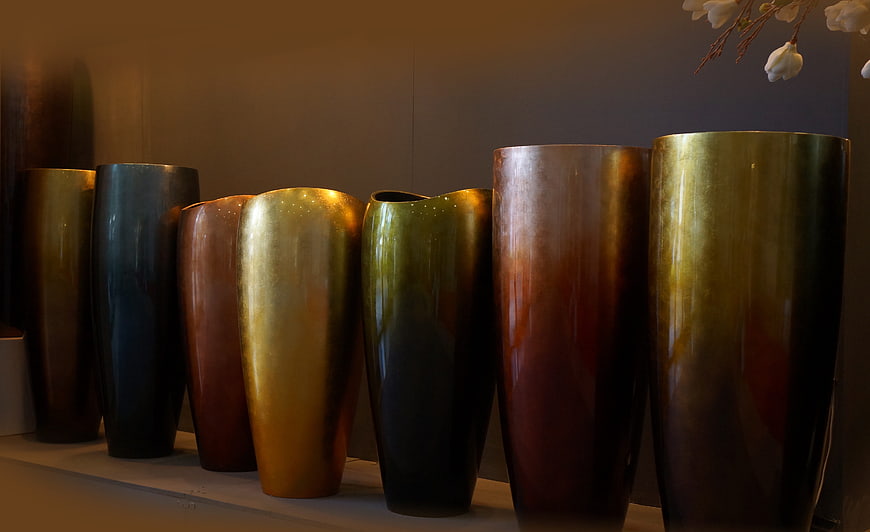 Colorful ceramic vases on a shelf with white flowers