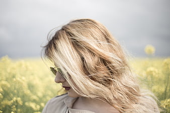 Blonde Woman with Windblown Hair in Yellow Flower Field