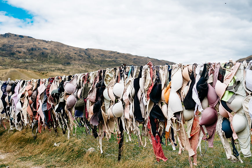 Colorful Bras Hanging on Fence in Mountain Landscape