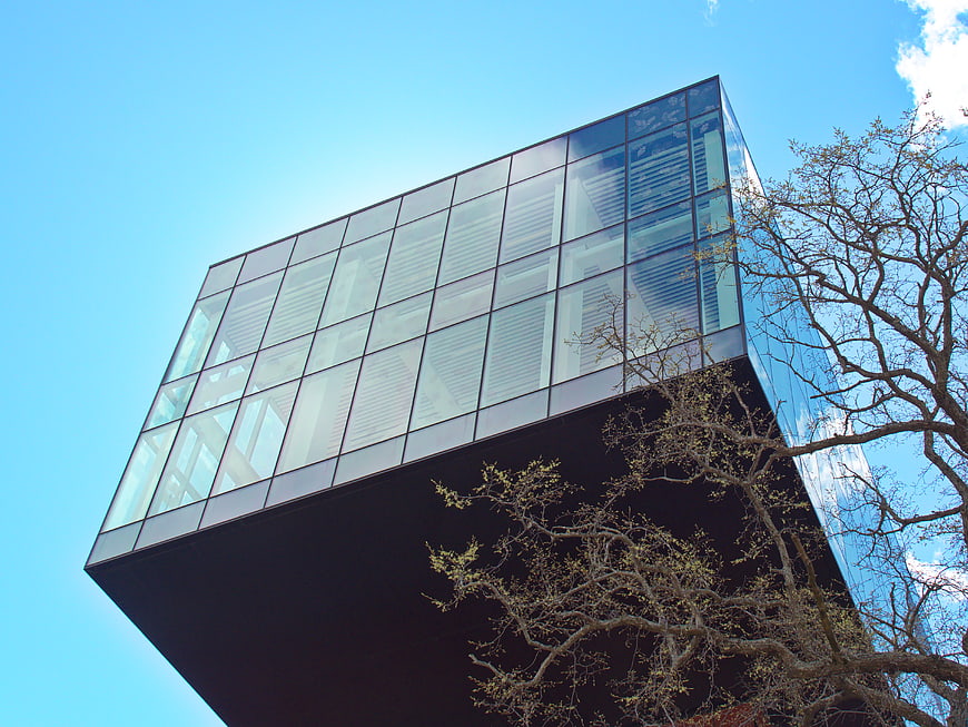 Low angle view of modern glass office building against blue sky
