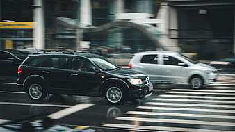 Black SUV Driving Fast on Wet City Street