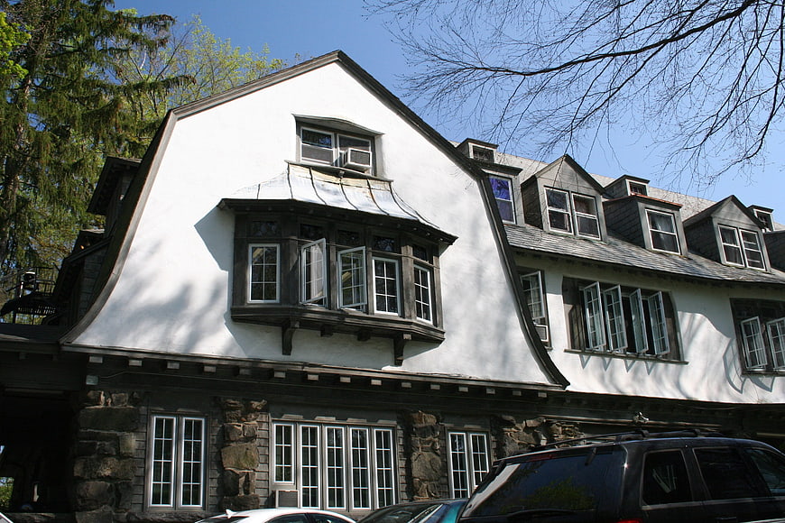Historic white building with curved roof and stone foundation