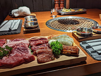 Korean BBQ platter with raw meat and grill
