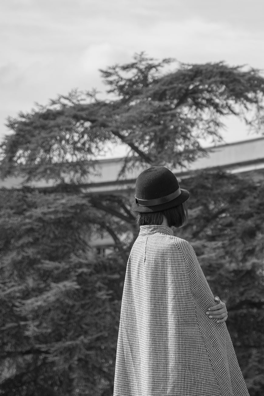 Woman in Fedora and Checkered Cape Back View