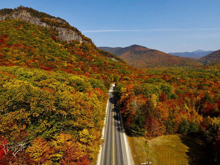 Aerial View of Winding Road Through Vibrant Autumn Mountains