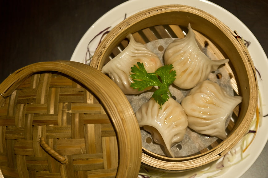 Steamed Dumplings in Bamboo Basket with Parsley Garnish