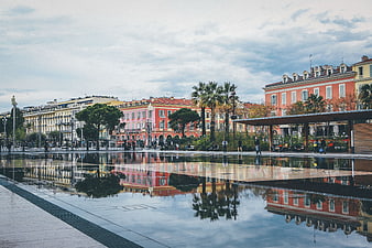 Colorful European city square with water reflection and architecture