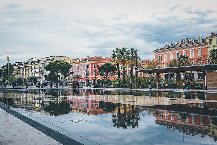 Colorful European city square with water reflection and architecture