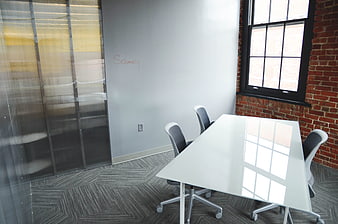 Modern office meeting room with white table and brick wall