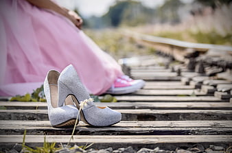 Silver glitter heels on train tracks with pink dress