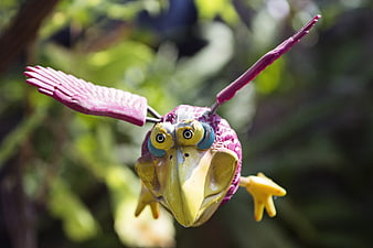 Colorful purple and yellow bird garden ornament in flight