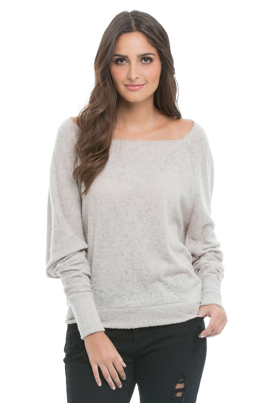 Woman in beige off-shoulder sweater and black jeans
