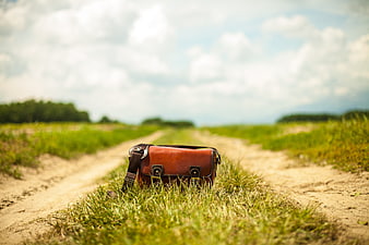 Vintage Leather Messenger Bag on a Rural Dirt Road