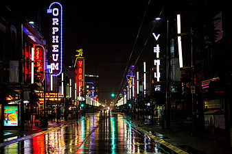 Neon-lit Granville Street in Vancouver at night with wet pavement reflections