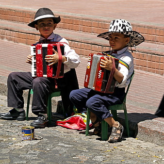Two young boys playing accordions on a street in Buenos Aires