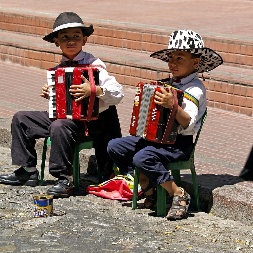 Two young boys playing accordions on a street in Buenos Aires