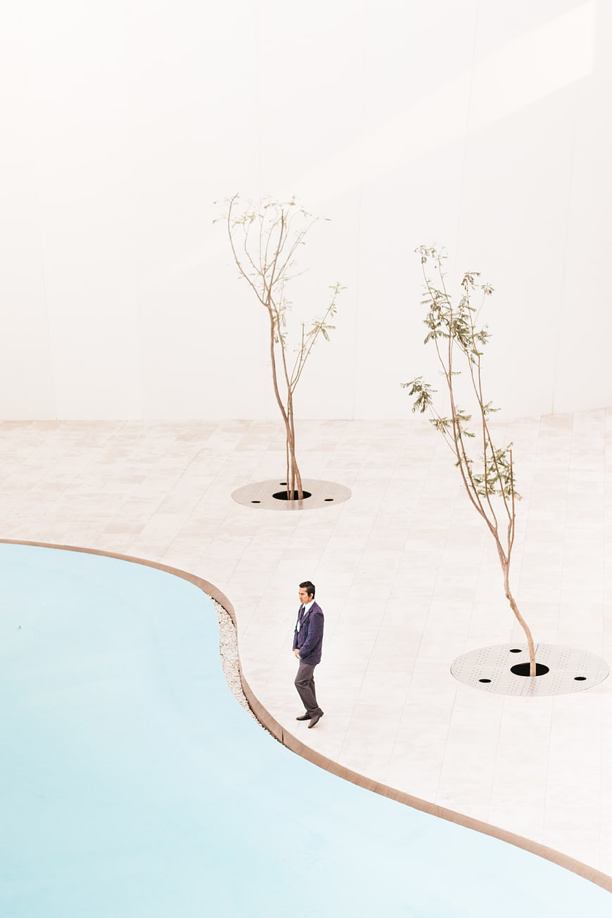 Businessman walking in minimalist white architectural courtyard