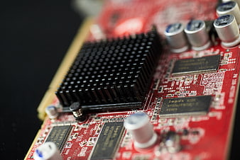 Close-up of red computer circuit board with black heatsink