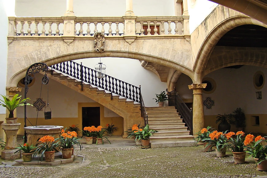 Historic Spanish Courtyard With Stone Staircase And Orange Flowers