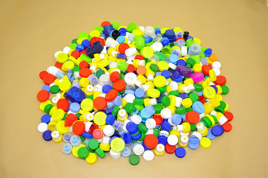 Colorful Plastic Bottle Caps Pile On Beige Surface