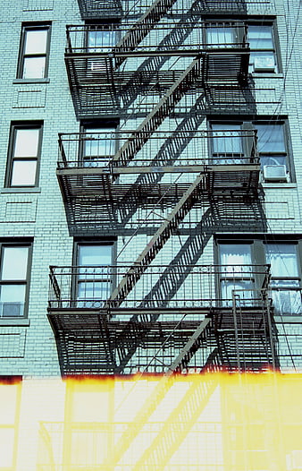 Urban Fire Escape on Blue Brick Building with Yellow Gradient