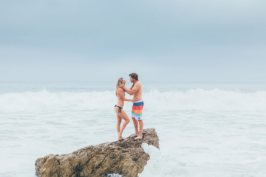 Couple Standing on Rock by Ocean Waves