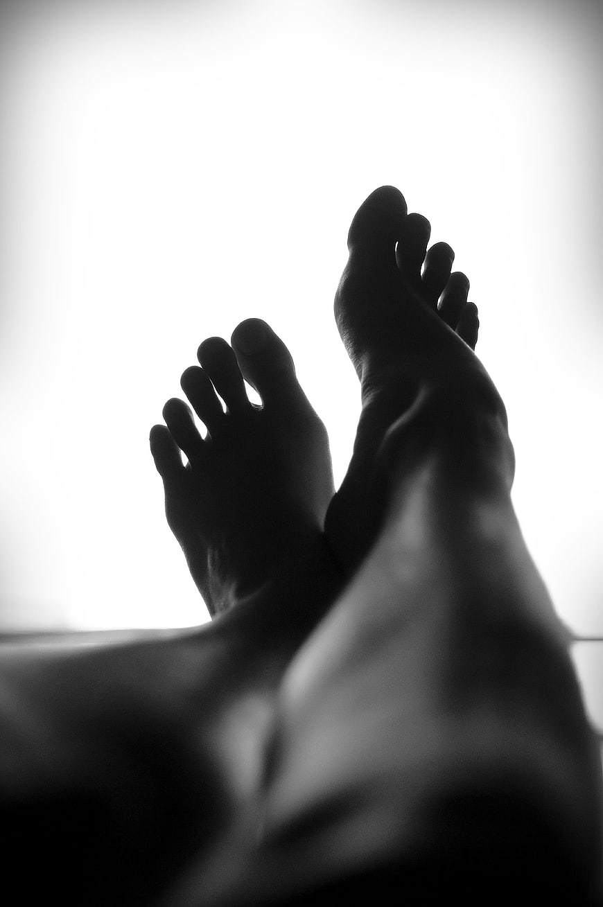 Silhouette of bare feet against bright white background