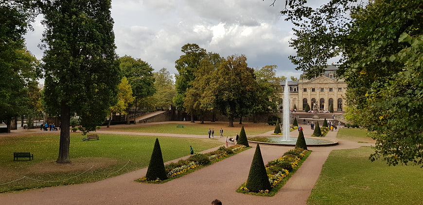 Wide view of formal park with fountain and classical building