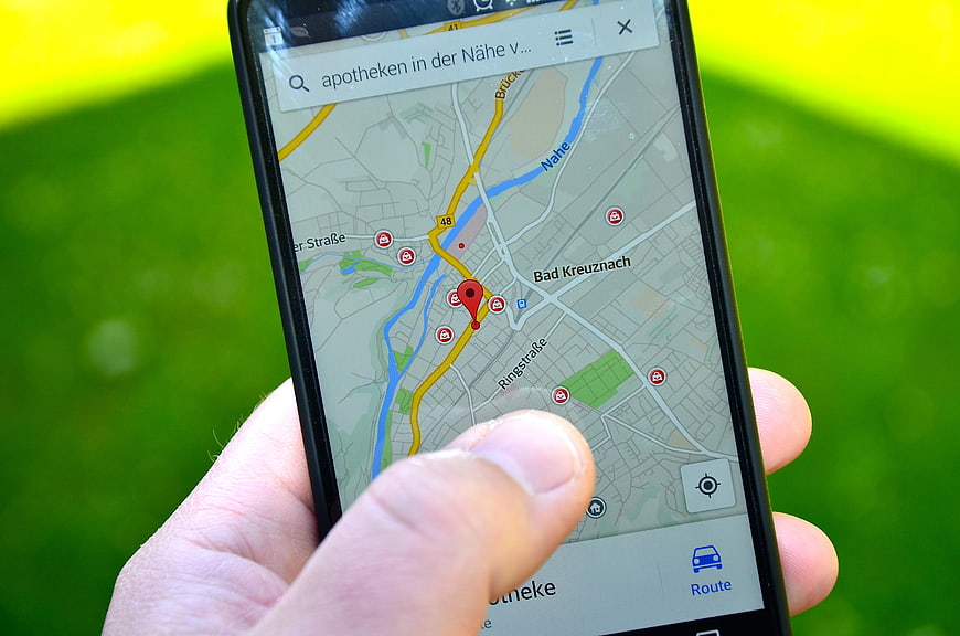 Hand holding smartphone with map navigation app