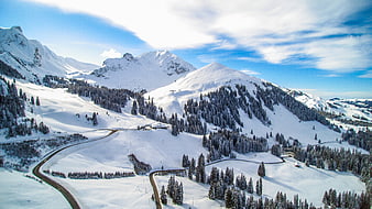 Aerial View of Snowy Mountain Pass with Winding Road