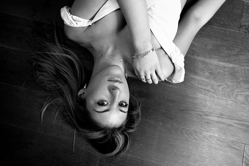 Black and white portrait of woman lying on floor