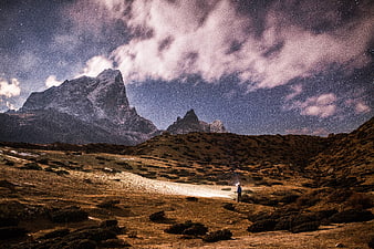 Hiker with Headlamp Under Starry Night Sky in Himalayas