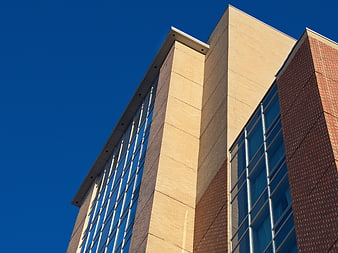 Modern Brick and Glass Building Facade Against Blue Sky